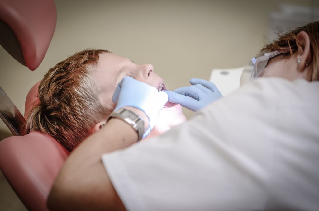 Dentiste qui effectue des soins dentaires sur un enfant